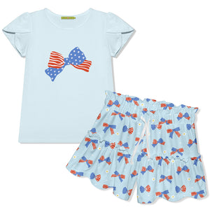 Children's outfit with light blue top and shorts featuring American flag designs and bows  on a white background