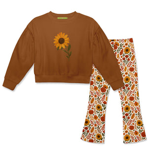 A children's two-piece set featuring a rust brown sweatshirt with a yellow sunflower graphic on the chest, and matching flared leggings with a sunflower, orange, and green floral pattern on a white background, Front
