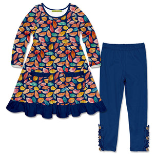 A children's two-piece outfit set featuring a long-sleeve dress with a colorful autumn leaf pattern on a navy blue base, and matching navy blue leggings with decorative wood buttons & ruffles at the cuffs.