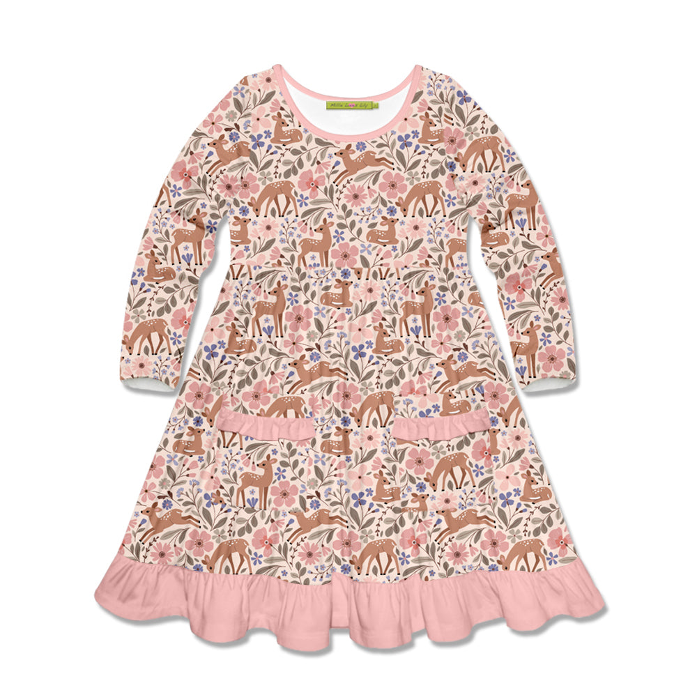 A long-sleeve children's dress with an all-over woodland print featuring deer, flowers, and leaves in pink, brown, beige, and blue tones, finished with a pink ruffled hem.
