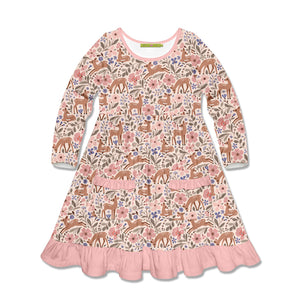 A long-sleeve children's dress with an all-over woodland print featuring deer, flowers, and leaves in pink, brown, beige, and blue tones, finished with a pink ruffled hem.