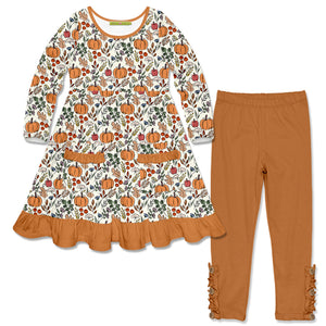 A two-piece girl's outfit set featuring a long-sleeve  dress with a and an all-over autumn pumpkin and leaf print, finished with a rust-orange ruffled hem, paired with matching rust-orange leggings.