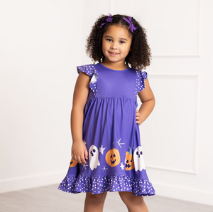 Young girl wearing a purple Halloween-themed dress with ghosts and pumpkins on a white background