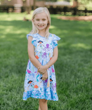 Young girls wearing a blue mermaid patterned dress standing outside in the grass, lifestyle, front - Millieloveslily.comt
