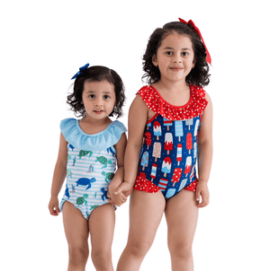 2 young girls wearing 1-pc swimsuits. One wearing a blue turtle themed swimsuit and the other wearing a red, white & blue popsicle print swimsuit, standing in front of a white background, lifestyle
