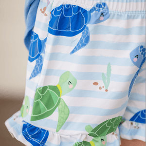 Close up of a girl wearing a turtle patterned short with ruffles, lifestyle