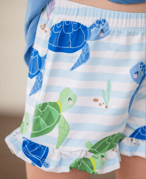 Close up of a girl wearing a turtle patterned short with ruffles, lifestyle