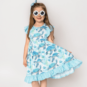 Young girls wearing a Mint Turtle patterned  Dress & Short Set and flower shaped sunglasses, lifestyle, front-Millieloveslily.com