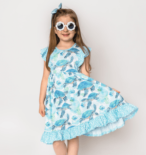 Young girls wearing a Mint Turtle patterned  Dress & Short Set and flower shaped sunglasses, lifestyle, front-Millieloveslily.com
