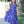 A young girl wearing a  Navy and Purple Floral Hi - Low Midi Dress with short sleeves standing outside in front of a fence, lifestyle