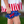 A closeup of a young girl standing outside wearing a matching red, white & blue stars and stripe short set with her hand on her hip, lifestyle