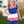 A young girl standing outside wearing a matching red, white & blue stars and stripe short set with her hand on her hip, lifestyle