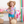 A young girl wearing a Turq & Pink Ocean themed  Rashguard and turquoise dot swim shorts carriyng a straw purse and wearing a straw hat, lifestyle, front