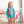 A young girl wearing a turquoise dot and Floral Rashguard Set and white floral sunglasses standing in a pool room, lifestyle- Millieloveslily.com