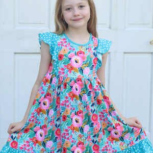 Young girl wearing a  Turquoise  Floral Angel Sleeve Dress and turquoise hair bow standing in front of a white background, front-Millieloveslily.com