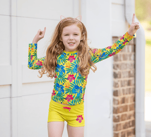 A young girl wearing  a yellow Neon Hawaiian print Long Sleeve Rashguard & swim short set standing in front of a white background, lifestyle UPF 50+, Millieloveslily.com
