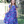 A young girl wearing a  Navy and Purple Floral Hi - Low Midi Dress with short sleeves standing outside in front of a fence, lifestyle