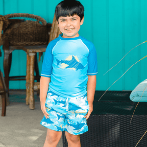 young boy standing outside wearing a Light Blue Shark themed Short - Sleeve Rashguard Set - Millieloveslily.com