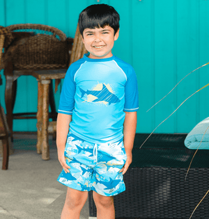 young boy standing outside wearing a Light Blue Shark themed Short - Sleeve Rashguard Set - Millieloveslily.com