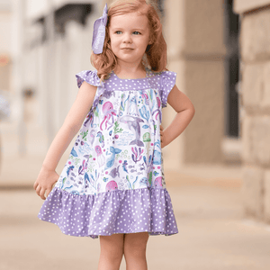 A young girl standing outside wearing a White & Purple Ocean animal themed Square Neck Angel Sleeve Dress - Millieloveslily.com