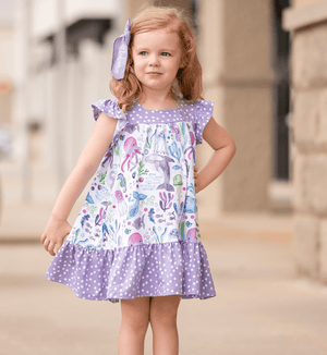A young girl standing outside wearing a White & Purple Ocean animal themed Square Neck Angel Sleeve Dress - Millieloveslily.com