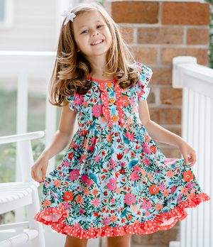 a young girl wearing a blue and orange  floral print Angel - Sleeve Dress standing outside, lifestyle- Millieloveslily.com