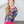 A young girl wearing a  navy and pink  Floral Long Sleeve Rashguard and swim shorts Set standing on a porch, lifestyle- 