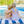 A boy and girl sitting poolside on a stripe towel, back