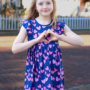 Girl wearing a heart printed dress- standing outside in a yard, lifestyle Millieloveslily.com