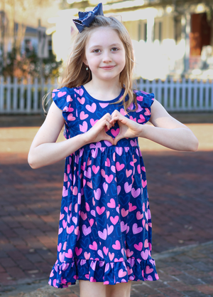 Girl wearing a heart printed dress- standing outside in a yard, lifestyle Millieloveslily.com