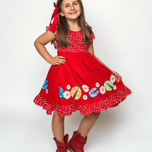 Young Girl wearing a red Ladybug Border patterned Dress & Shorts standing on an off white background, lifestyle, front - Millieloveslily.com