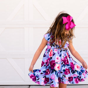 girls wearing a periwinkle floral  Angel Wing Dress standing in front of a white background, lifestyle  - Millieloveslily.com
